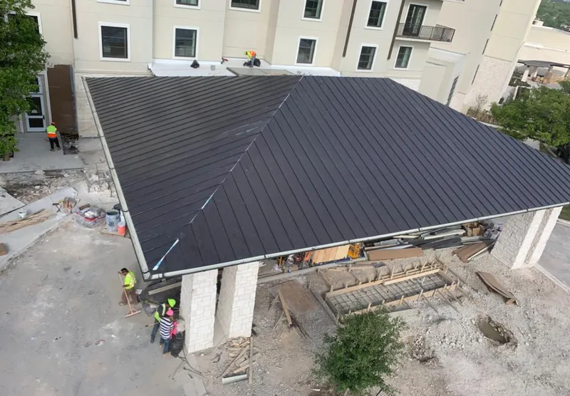 Metal roofing installation team working on a commercial building in St. Albans